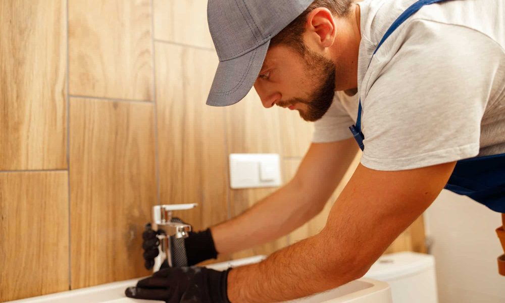serious-plumber-male-worker-in-uniform-installing-tap-or-bathroom-faucet.jpg